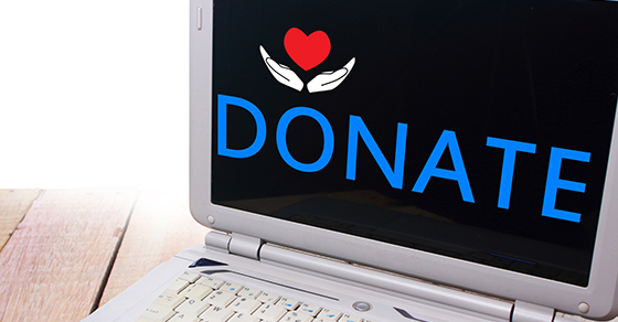 computer screen with word donate and icon of two hands holding a heart