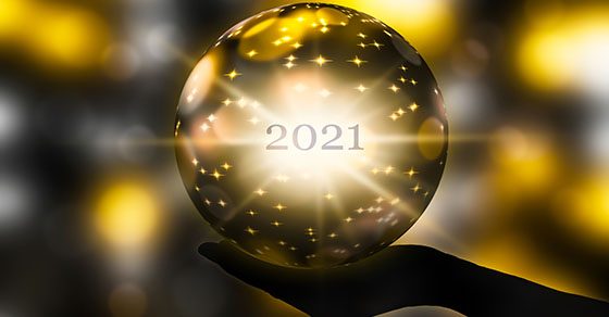 crystal ball in a hand, prediction for new year 2021 on abstract shiny blurred background