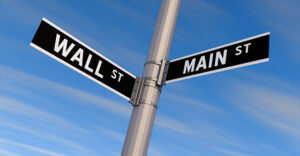 street sign showing two streets - one side says Wall St. and the other says Main St.