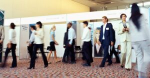 conference room with multiple attendees walking around, blurry to show motion of people