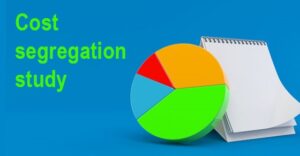 blue background with bright green words reading cost segregation study next to a pie chart and blank notepad