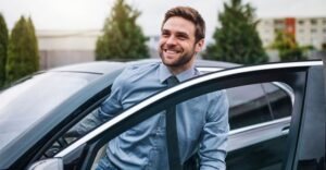 man getting out of the drivers side of a car while smiling