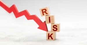 downward red trend line arrow with blocks stacked with letters reading RISK