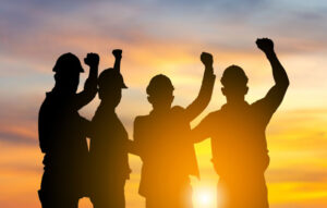 Silhouette of worker team with clipping path joining hands and celebration with sunset background, Success, Union, and Teamwork Concepts