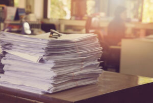 Stack of business papers on a desk with a vintage filter to indicate older paperwork