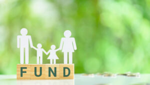Family, a father, a mother with two children stand on wood cubes with the word FUND, depicting charitable activities. 