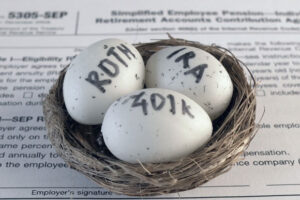 Conceptual composition representing IRS limits. Pension savings. Individual retirement account. Three eggs with the inscriptions IRA, 401k, Roth lie in the nest against the background of the 5305-SEP form. Close-up
