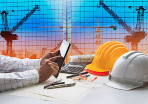 hand of architect working on table with tablet computer on cost segregation study. Working tool equipment is against reflection of office building and crane construction use for civil engineering and construction industry business