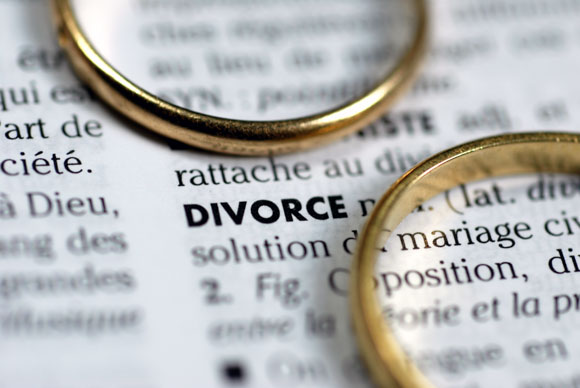 wedding rings sitting on dictionary page on definition of divorce. 