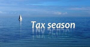 open water with sailboat in the background. Words tax season floating on water surface