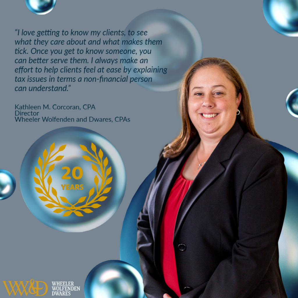 Photo of Kathy wearing red shirt and black suit coat smiling at camera with quote "I love getting to know my clients, to see what they care about and what makes them tick. Once you get to know someone, you can better serve them. I always make an effort to help clients feel at ease by explaining tax issues in terms a non-financial person can understand" above 20 years emblem. Grey background with blue and green gradient bubbles in background.