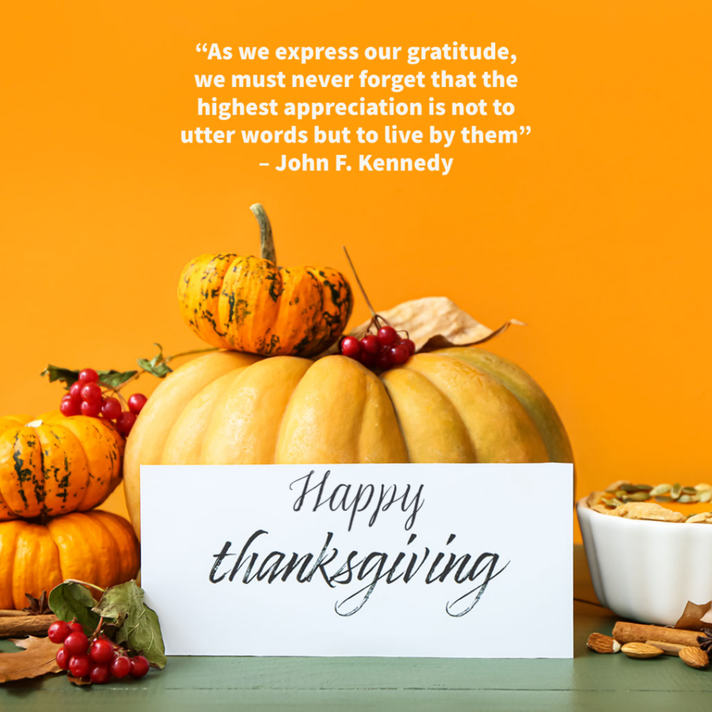 pumpkins of different sizes stacked together next to pumpkin soup with sign that says happy thanksgiving. Quote from JFK across top reads "as we express our gratitude, we must never forget that the highest appreciation is not to utter words but to live by them"